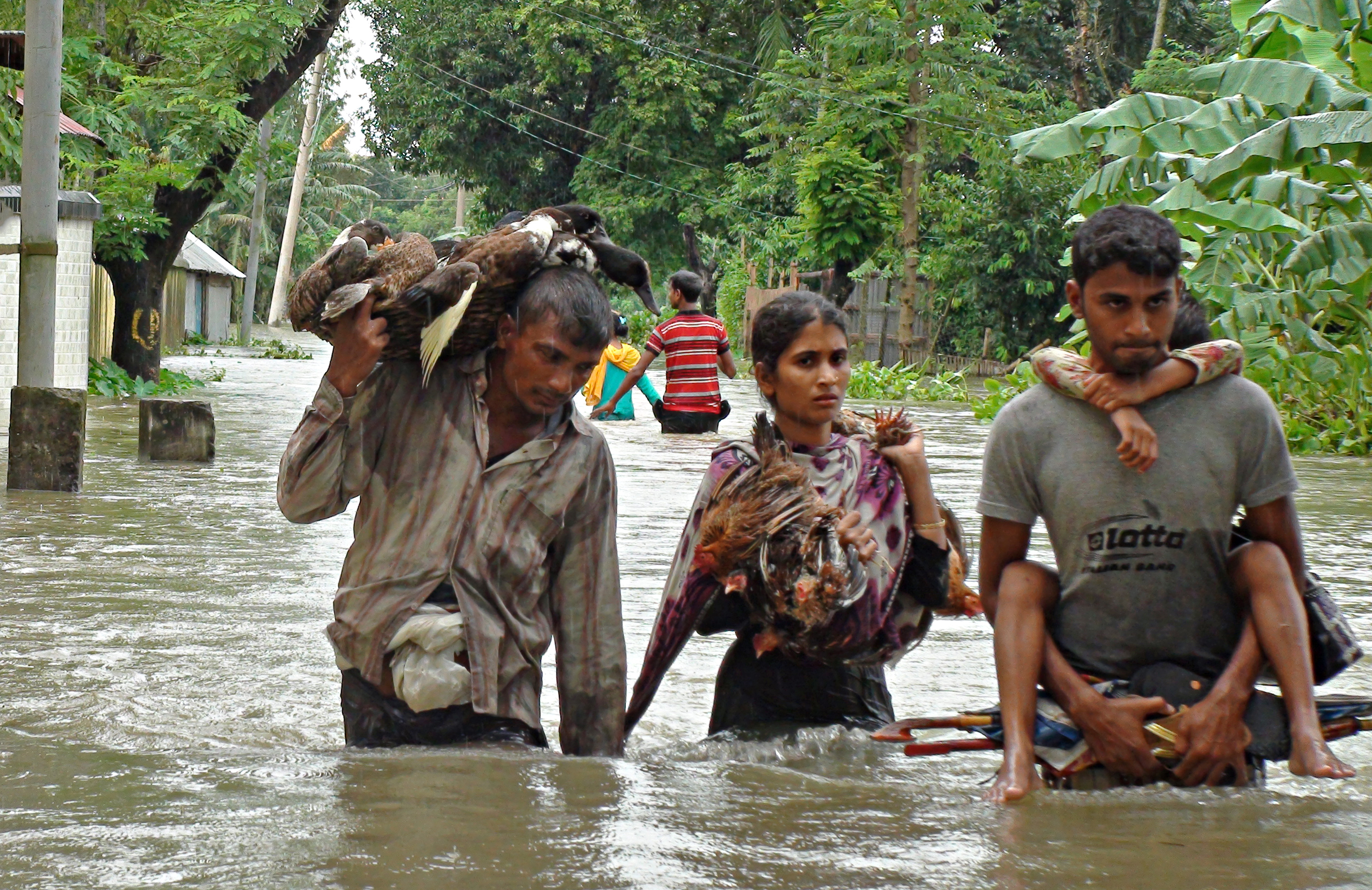 People in Lalmonirhat District, Bangladesh, move to the nearest flood shelter during the 2017 monsoon season