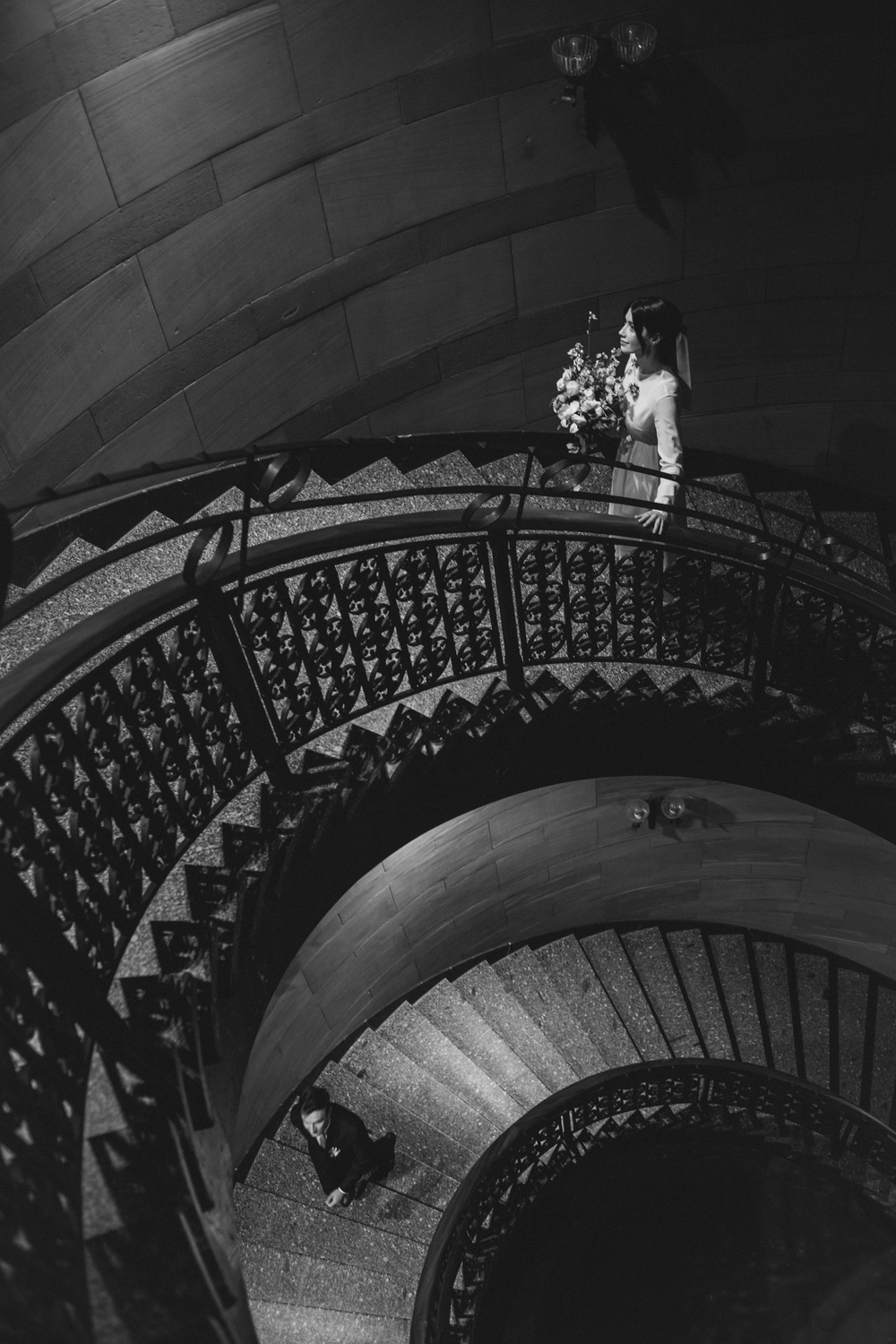Zdjęcia ślubne Poznań - para młoda wchodząca po krętych schodach - zdjęcie czarno-białe