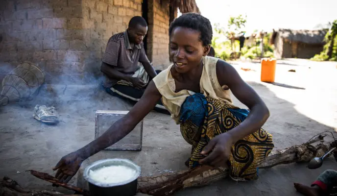 Woman prepares breakfast to share with her husband Eric and their children in the village of Pension, Manono Territory.