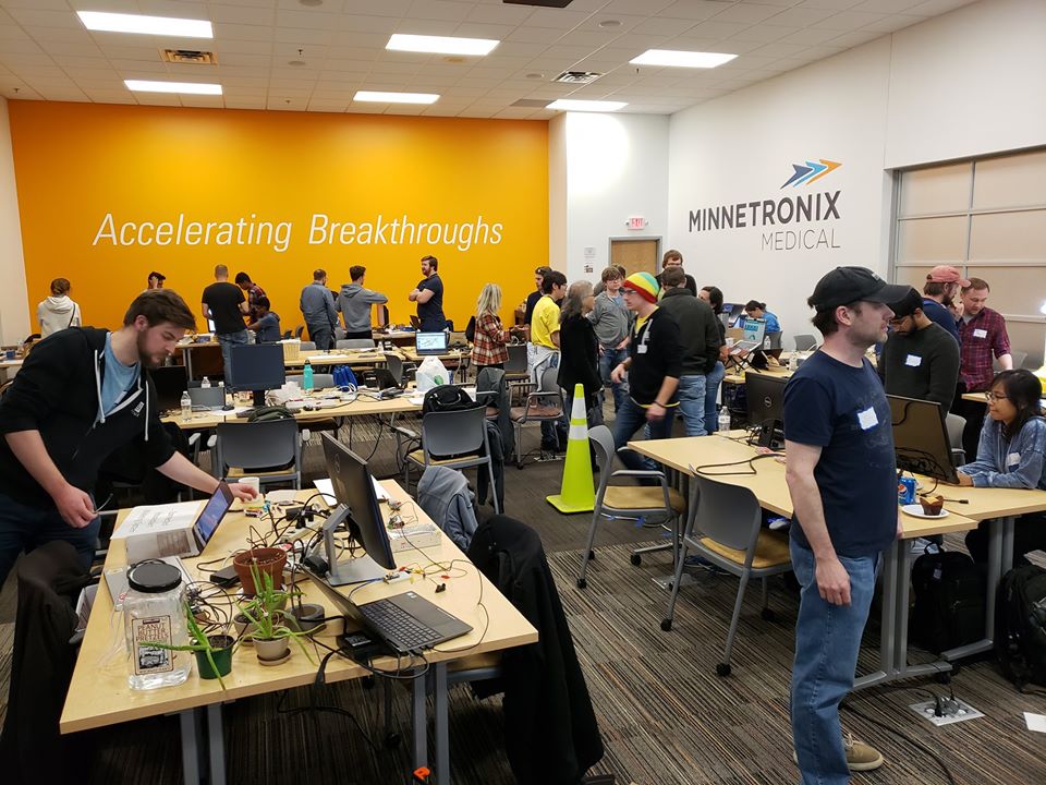 Groups of people at different work tables at IoT HackDay hackathon