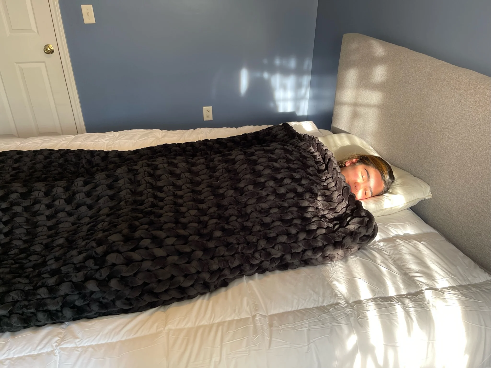 a reviewer taking a nap with hush knit weighted blanket in sleepiverse studio