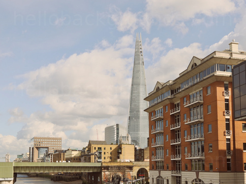 Urban London view of The Shard building with its many reflective windows with red brick multi-story building in front Skype background