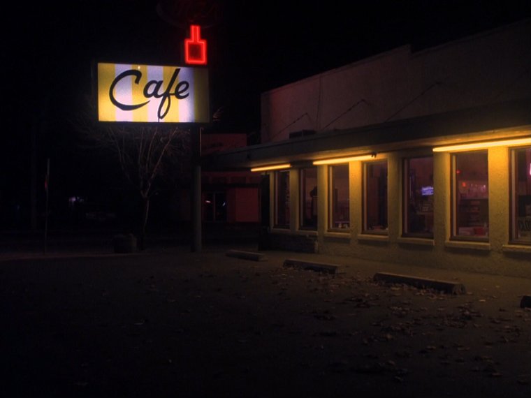 atmospheric night view of a cafe with a red neon sign