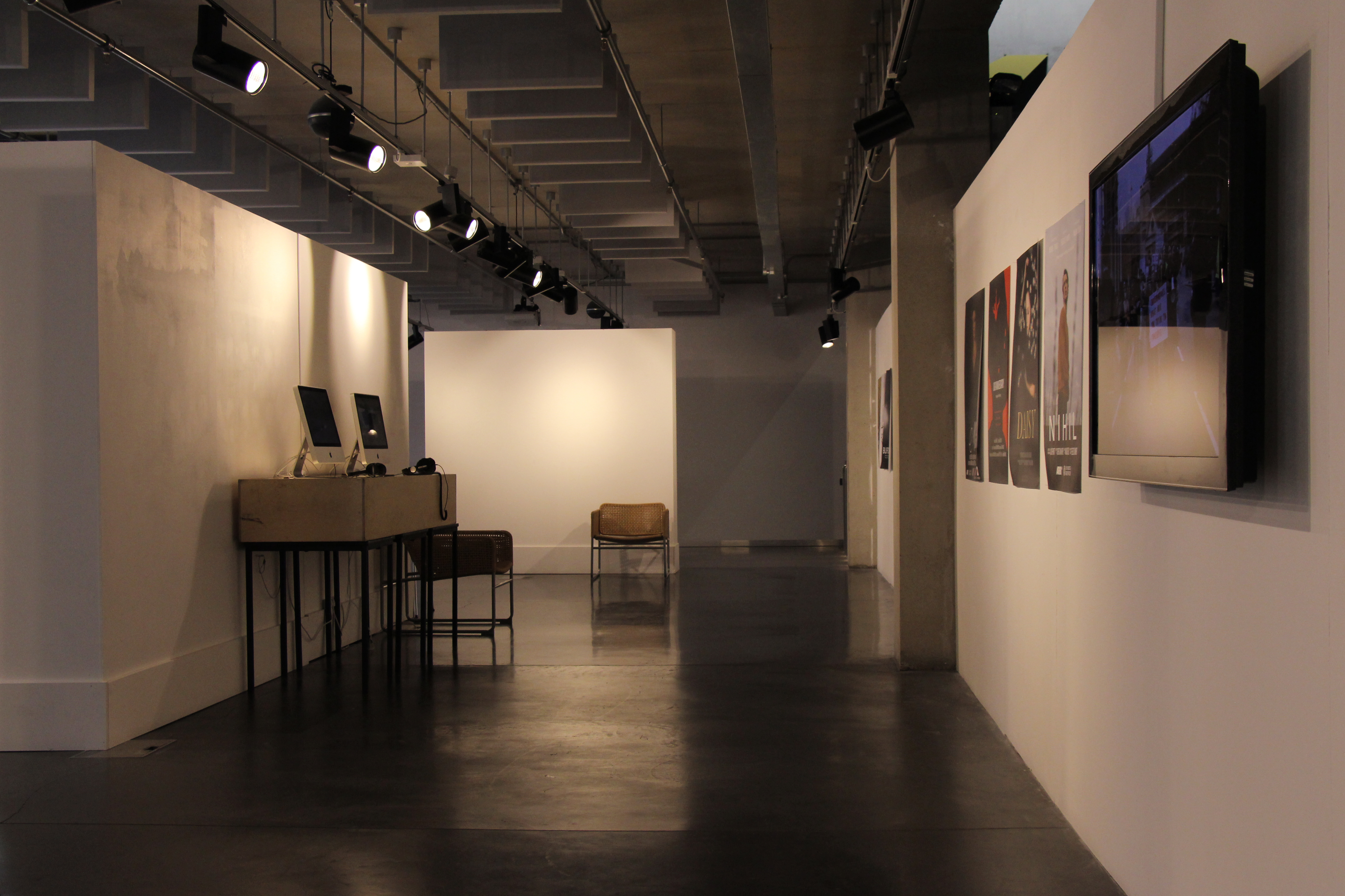A gallery with posters, a tv screen, and computers installed