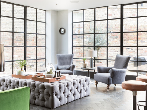 Refined lounge area with purple and modern chesterfield furniture design theme and large floor to ceiling windows Google Meet background