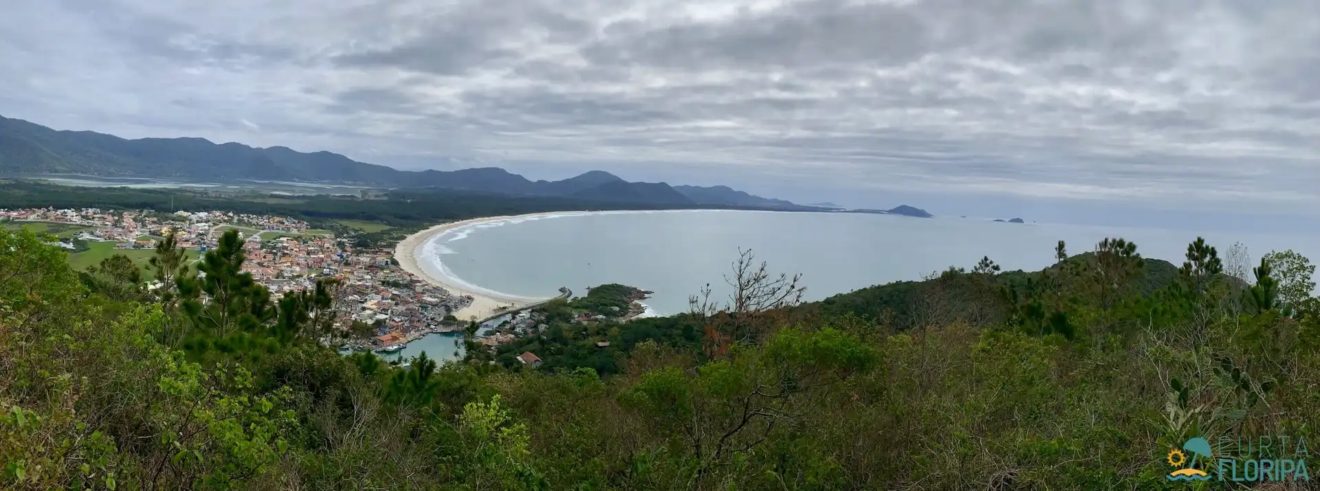 Vista aérea do canal da barra da lagoa com mar a direita e cidade a esquerda