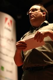 Jared Spool on stage opening an envelope.