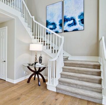 staircase with white painted rails and a light grey painted wall