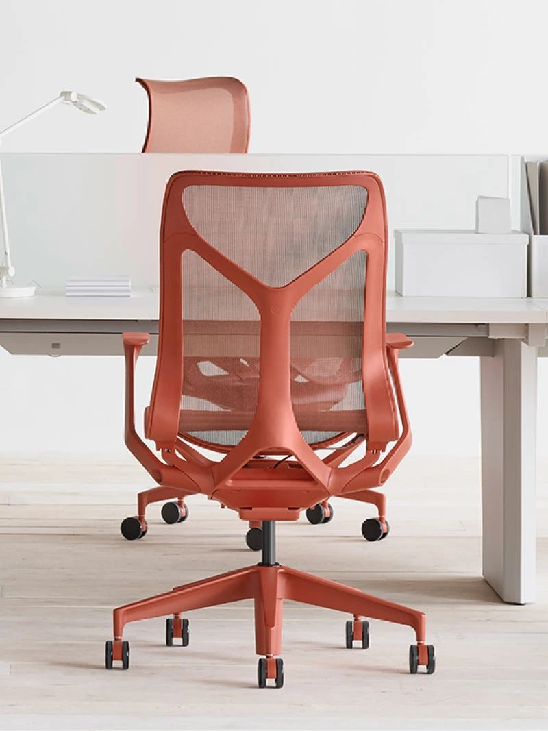 Red MillerKnoll desk chair in front of sleek office desk.