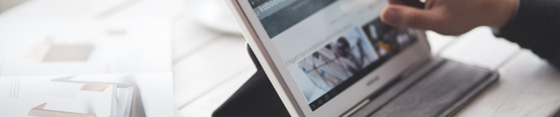 Ein Mensch arbeitet mit einem Tablet am Schreibtisch