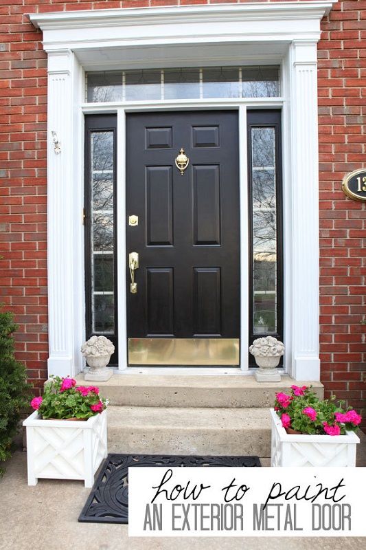 enlarged photo of newly painted dark ebony door surround by windows with white framing in a brick house