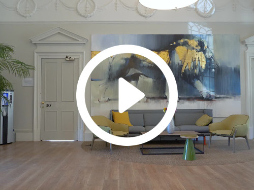 Spacious private office with ornate white cornice above modern art painting of lion and grey sofa and green chairs Microsoft Teams background