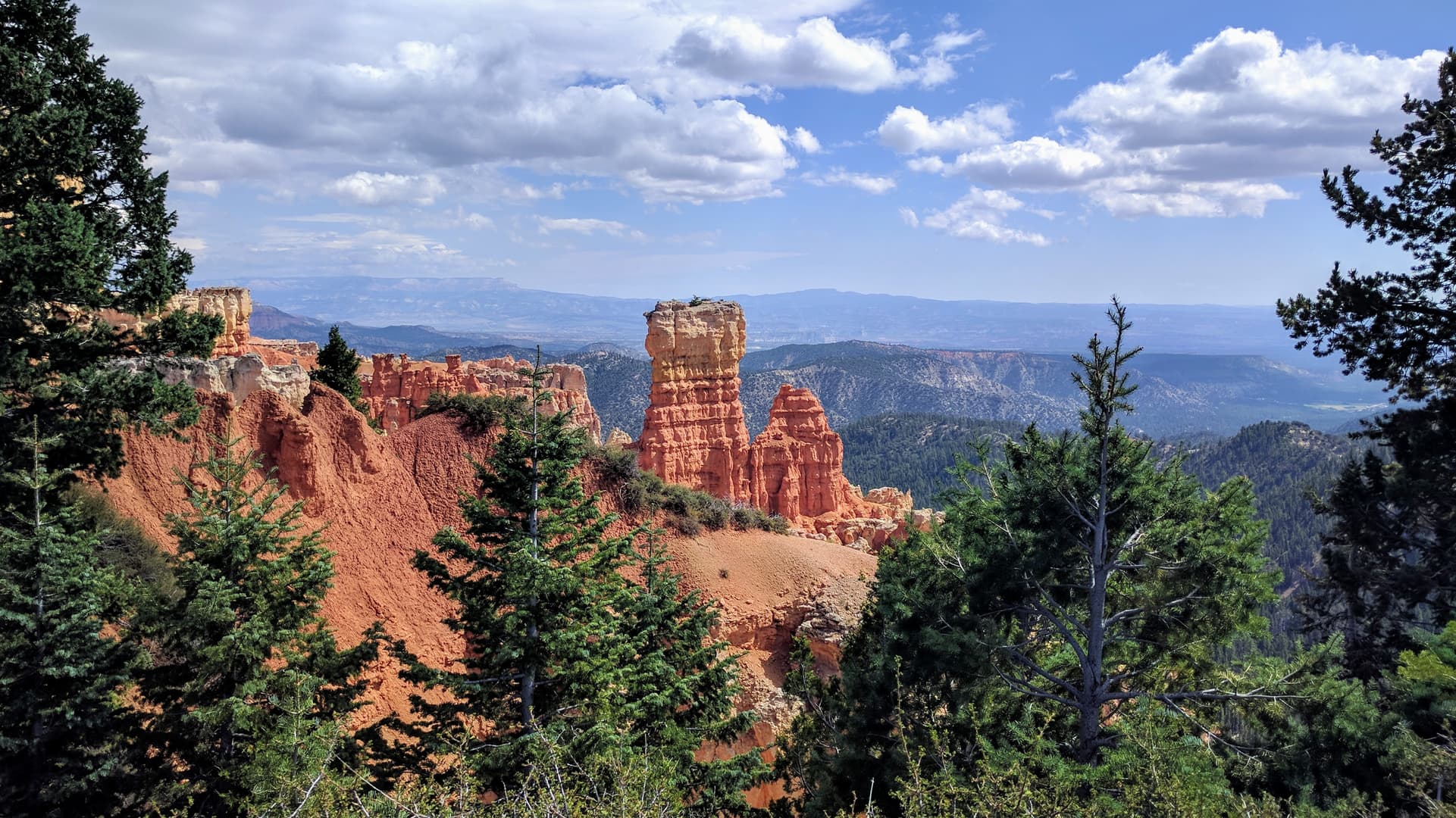 A fin of soft red and white rock extends from the South Wall of Bryce Canyon. It abruptly ends in two wide pillars of rock.