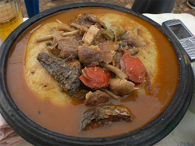 An eathenware pot filled with fufuo and soup.