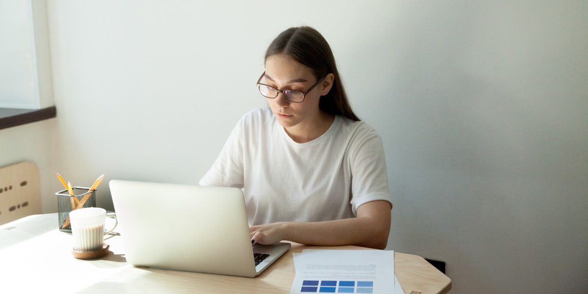 UI designer choosing a color palette Woman sitting at a desk with a laptop in front of her