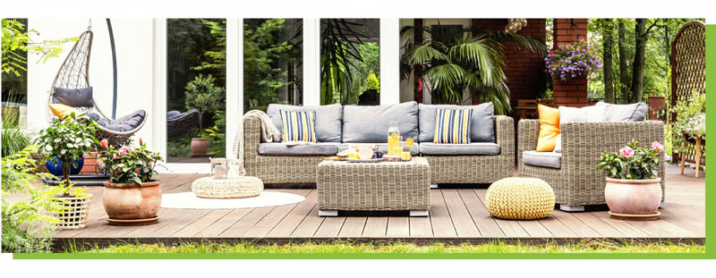 TBeautiful outdoor furniture on a deck with a tropical garden in the background