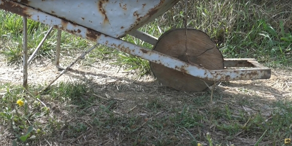Une brouette rouillée avec une roue en bois