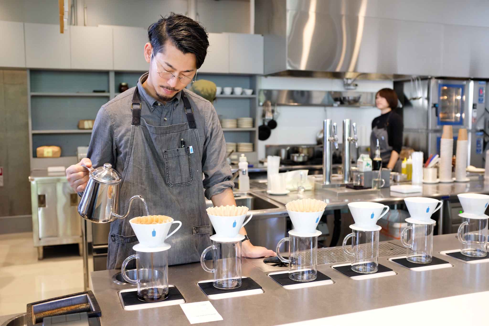 A Blue Bottle barista using their special designed drippers