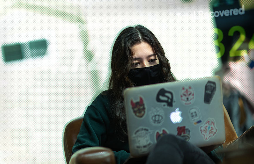 A young adult wearing a mask participates in an online COVID-19 survey