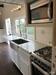 A Zen Tiny House gooseneck home; another view of the kitchen with light worktop and cabinets, gas stove and a good sized sink. A Zen Tiny House gooseneck home; another view of the kitchen with light worktop and cabinets, gas stove and a good sized sink.