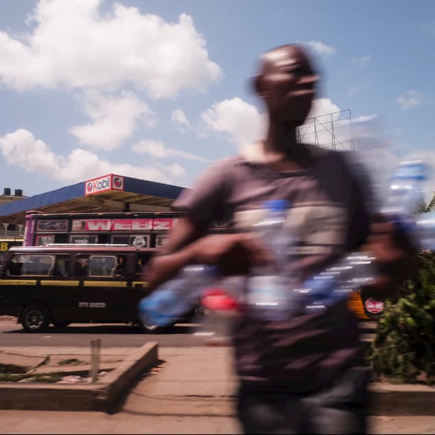 Young man crossing the street in Nairobi's busy traffic.