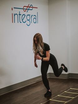 Kaitlyn Sosnowski performing agility ladder drills in front of the Integral logo.