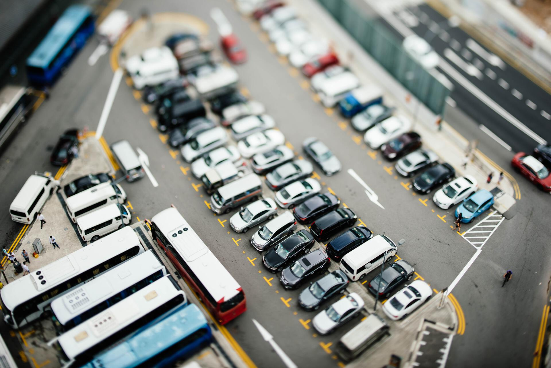 A birdview of several cars parked next to each other on a parking lot.