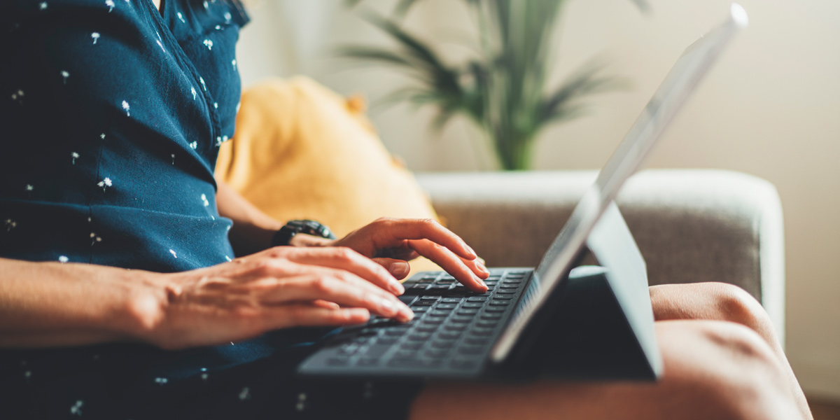 How to Write an Amazing Product Page UX writer sitting on a couch with their laptop.