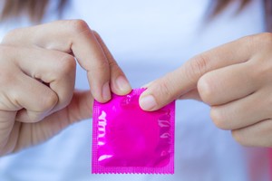 Hand holding condom safe sex contraception STDs STIs