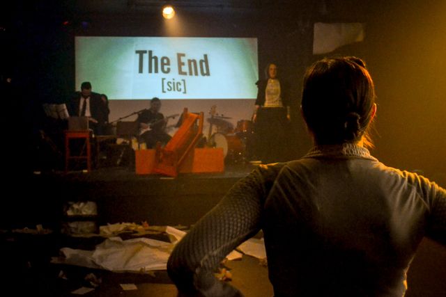 Shot over Jane's shoulder,
talking to Narrator Jane (Miriam) on stage.
Projection says The End (sic).
