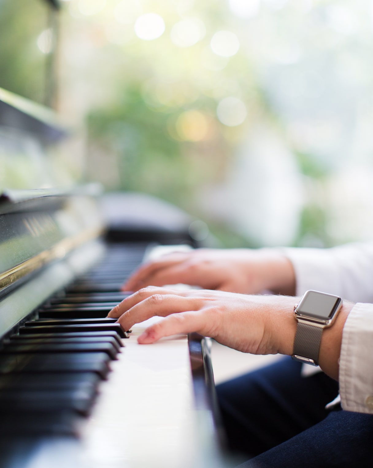 Jack Watkins, wedding pianist leaning on black Yamaha upright piano