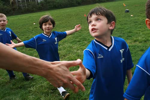 kids shaking hands after soccer game