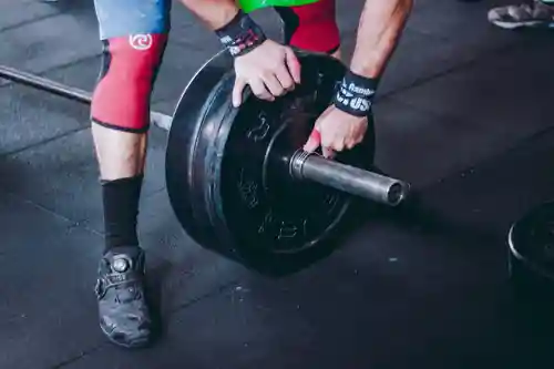 Bodybuilder adjusting weights on bar