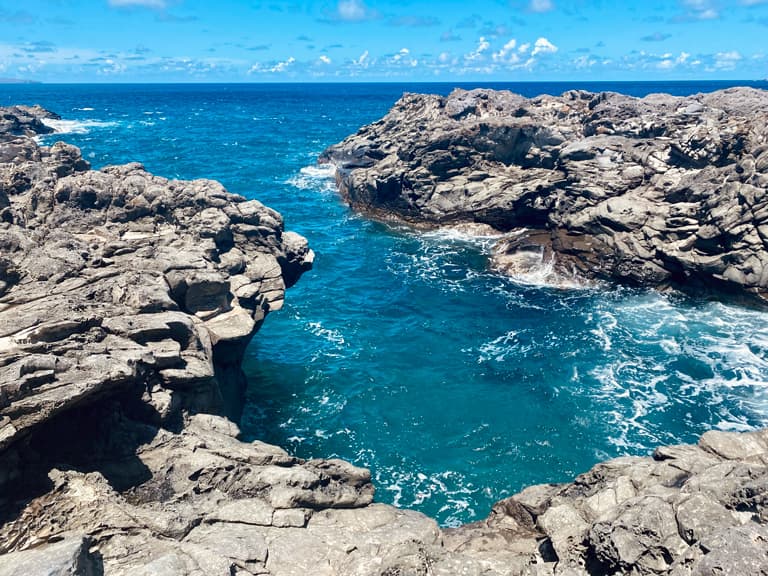 A cove of crystalline, turquoise water sweeping into a rocky coastline