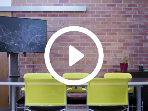 Intimate meeting room with exposed brick walls behind television and black table surrounded by modern yellow chairs  Google Meet background