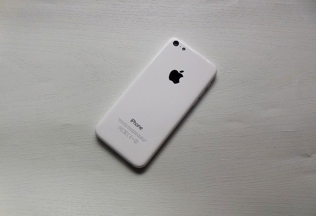 An iPhone 5c placed face-down on a desk