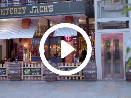 Restaurant shop front featuring corrugated iron sheltered roofing above decorative wooden picket fence and barrel sections  Skype background