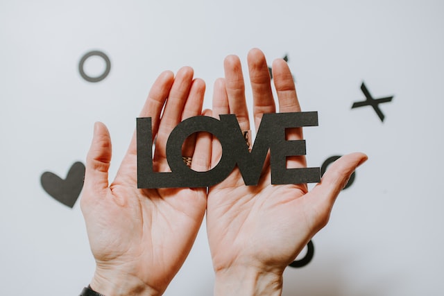 Hands holding letters forming the word 'LOVE'