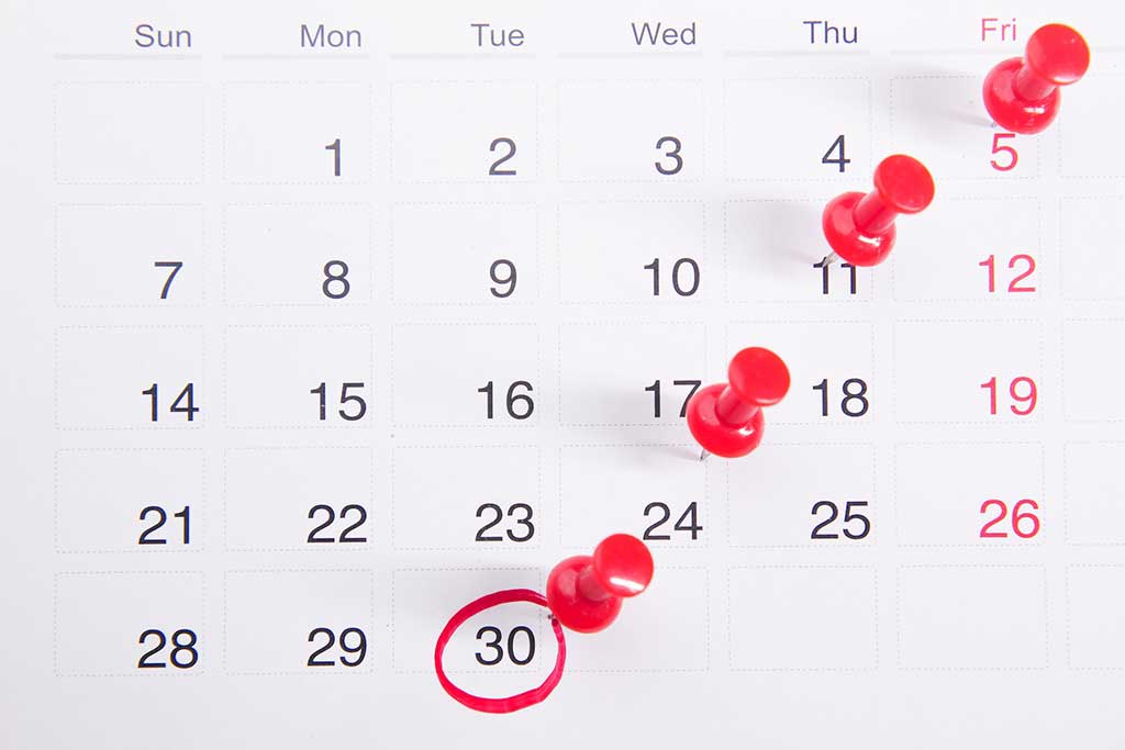 A close up shot of a calendar with pins in some days and a red ring around the 30th, Photo by Towfiqu barbhuiya on Unsplash.