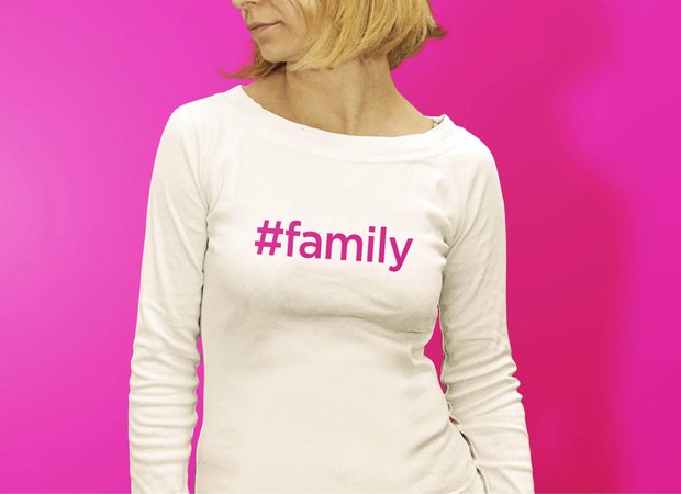A lady wearing a t-shirt with the hashtag #family written on it
