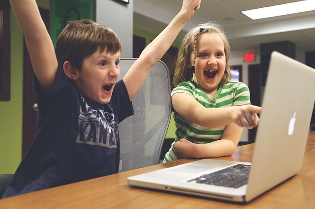 Children celebrating while playing computer game