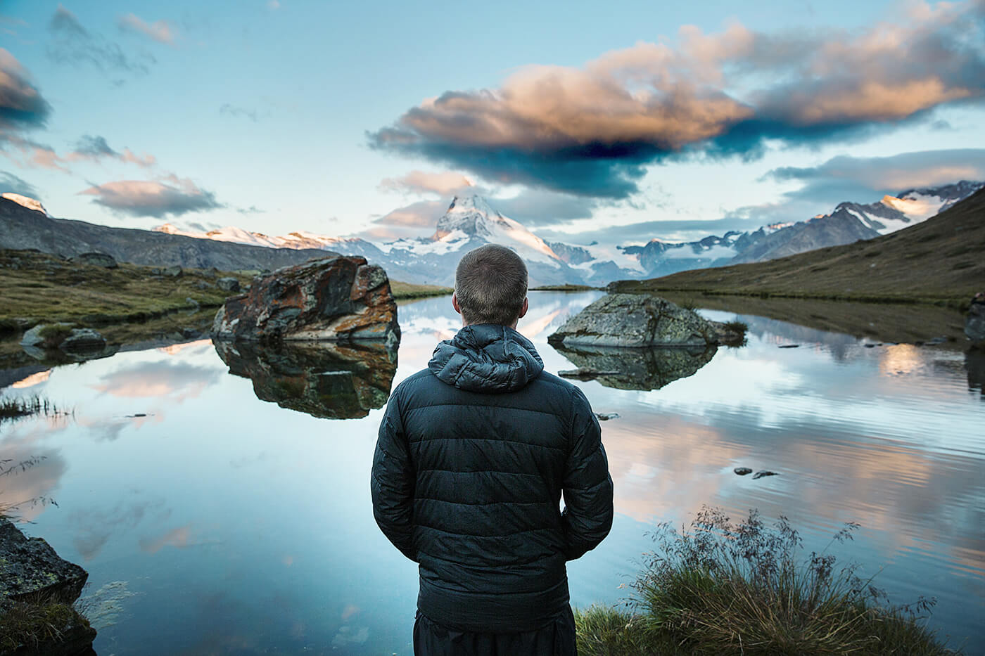 A man looking at a beautiful lake and mountains landscape in Switzerland
