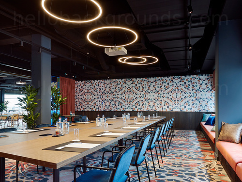 Artistically styled boardroom adorned with multiple pattern designs containing a long wooden table and circular lighting   Microsoft Teams background