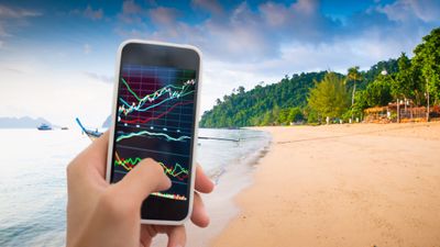 Stock trading on a mobile phone on a tropical beach