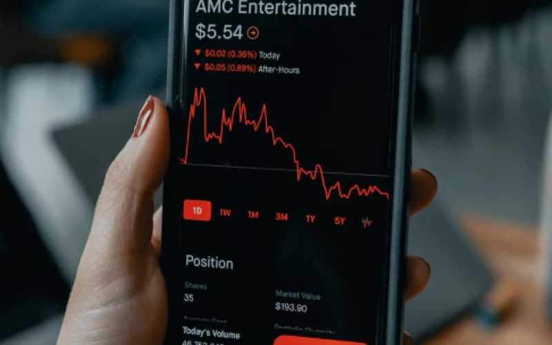 Close-up of a smartphone in a hand with stocks chart shown on the screen