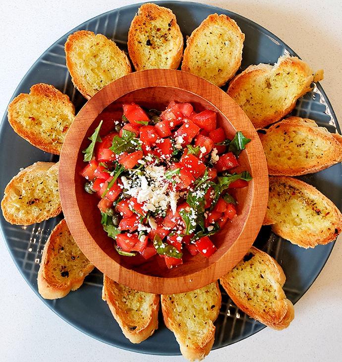 Plate with Mediterranean bruschetta served with baguette