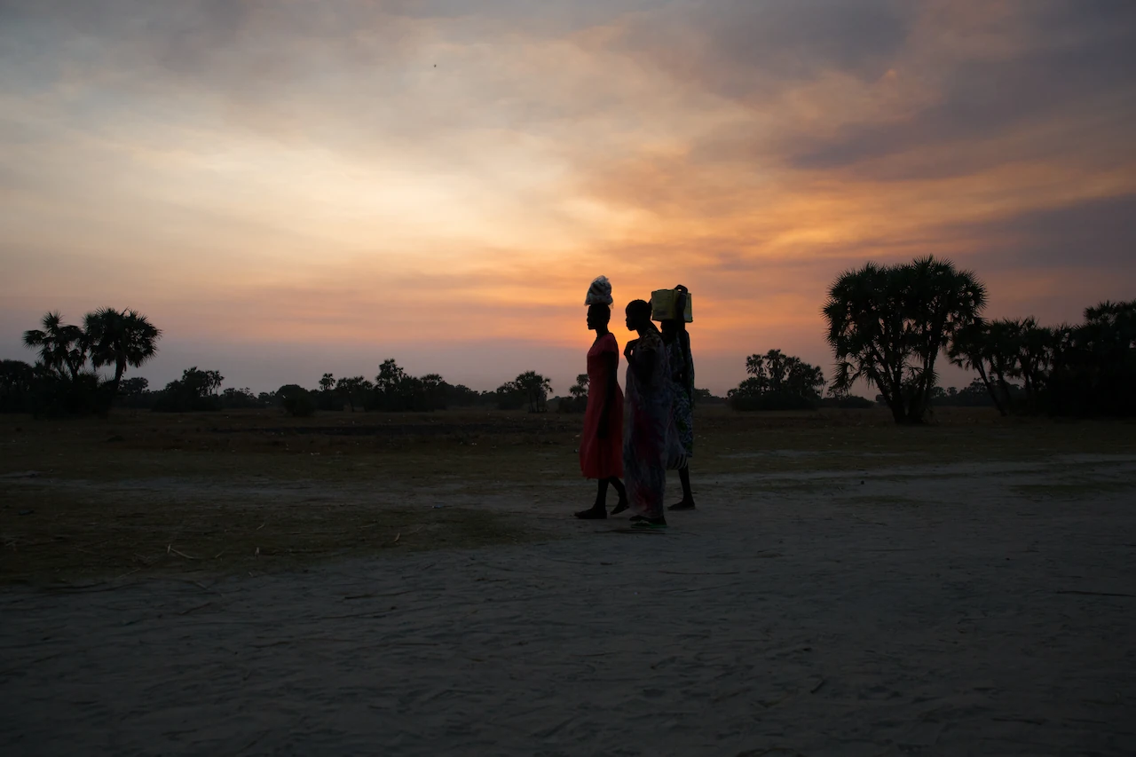 Women collecting water at dusk in South Sudan