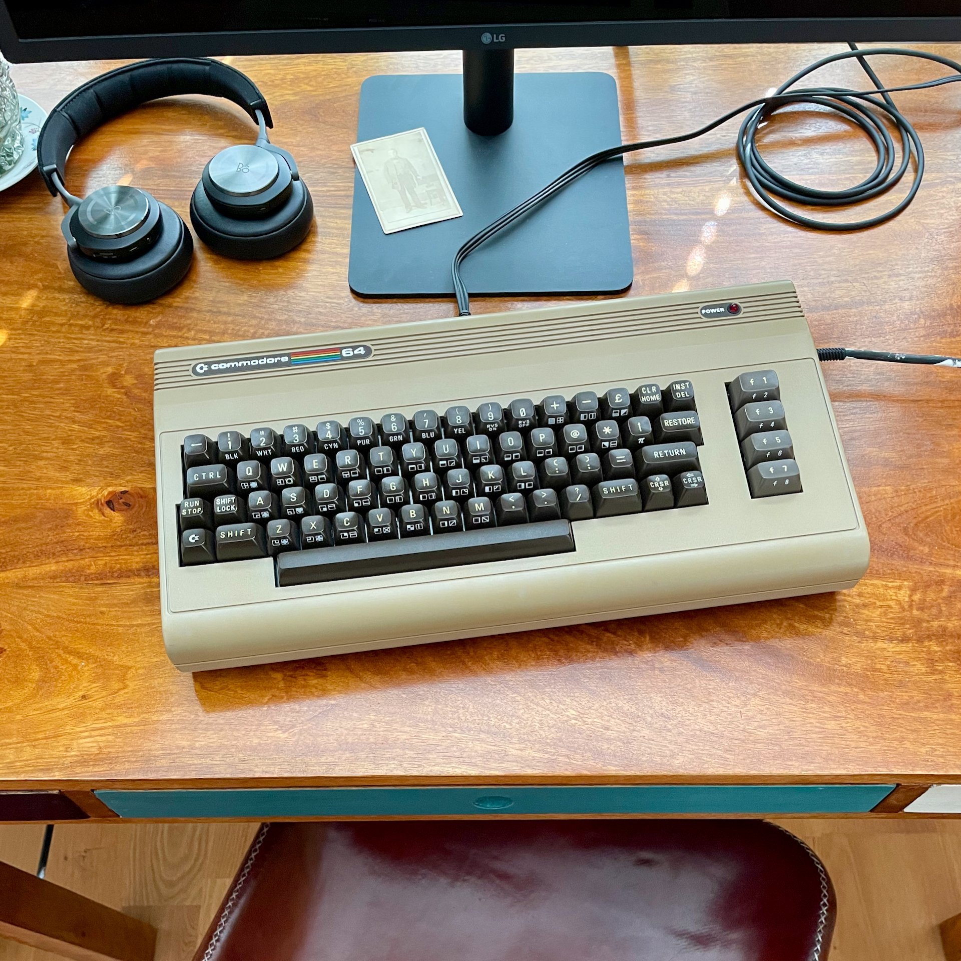 An old, but pretty looking, Commodore 64 computer on a desk.