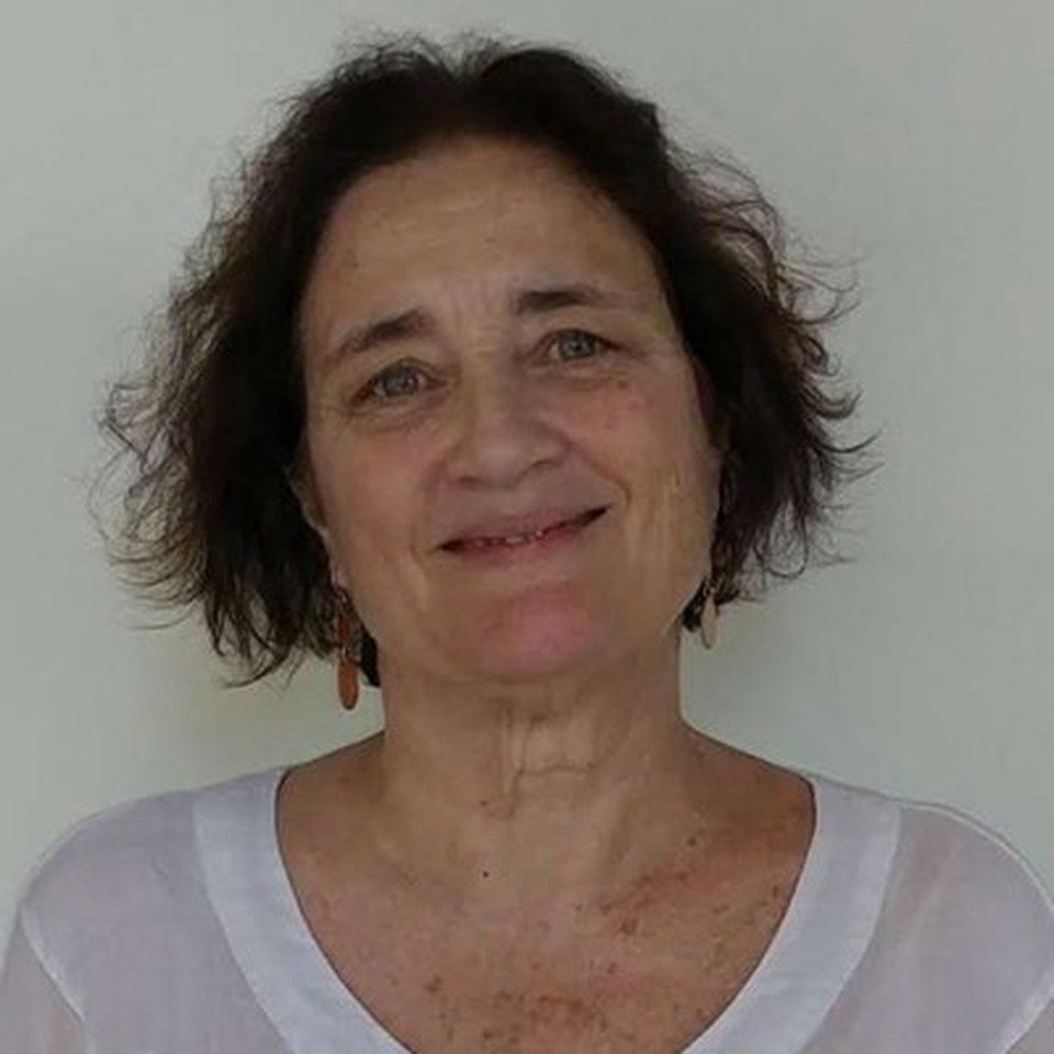 Professor Stephanie Baus - smiling and wearing a white shirt