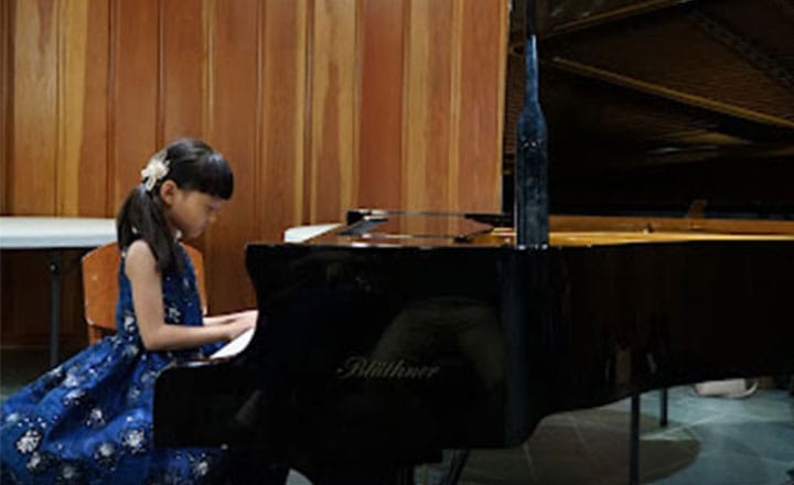 two students performing piano and flute